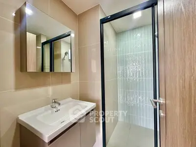 Modern bathroom with sleek shower and stylish vanity in contemporary apartment.