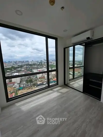 Stunning city view from modern high-rise apartment with large windows and sleek flooring.