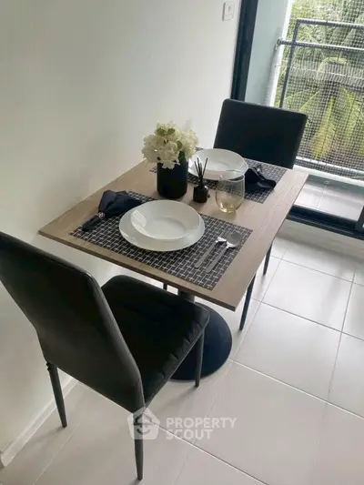 Chic dining area with modern table setting and balcony view in stylish apartment.