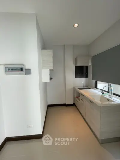 Modern kitchen with sleek cabinetry and large window for natural light