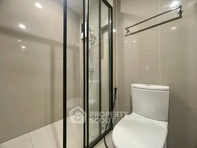 Modern bathroom with glass shower enclosure and sleek toilet design.