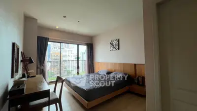 Spacious bedroom with city view, modern furnishings, and natural light