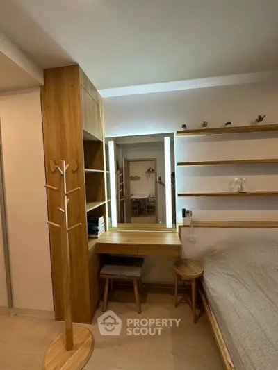 Modern bedroom with wooden furniture and built-in shelves, featuring a stylish vanity mirror and cozy ambiance.