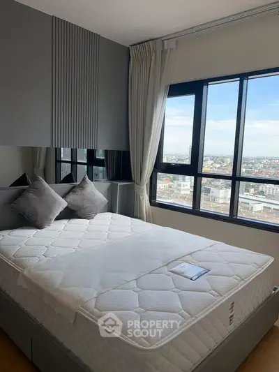 Modern bedroom with large windows offering stunning city views, featuring a comfortable bed and elegant decor.