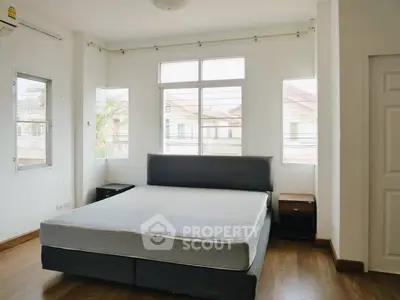 Spacious bedroom with large windows and modern decor in a bright home.