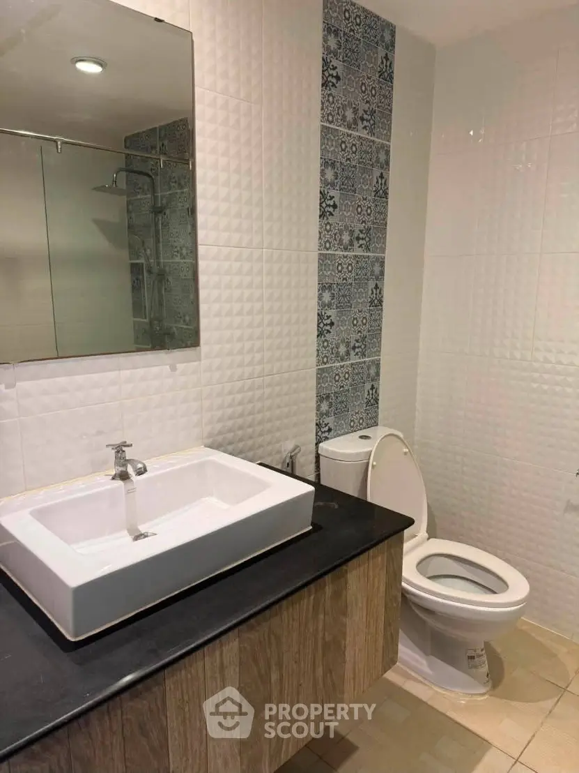 Modern bathroom with stylish sink and patterned tiles, perfect for a contemporary home.