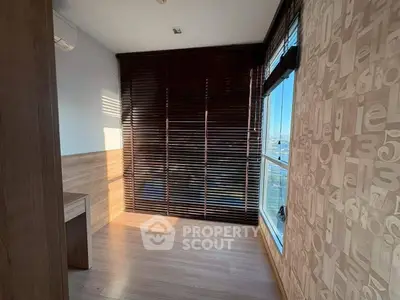 Bright room with wooden blinds and modern wallpaper, perfect for a cozy study or small bedroom.