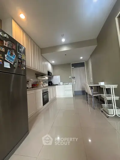 Modern kitchen with sleek appliances and dining area in a stylish apartment.