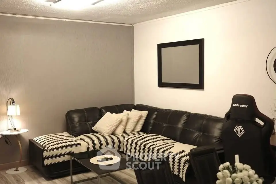 Modern living room with stylish black leather sofa and chic decor