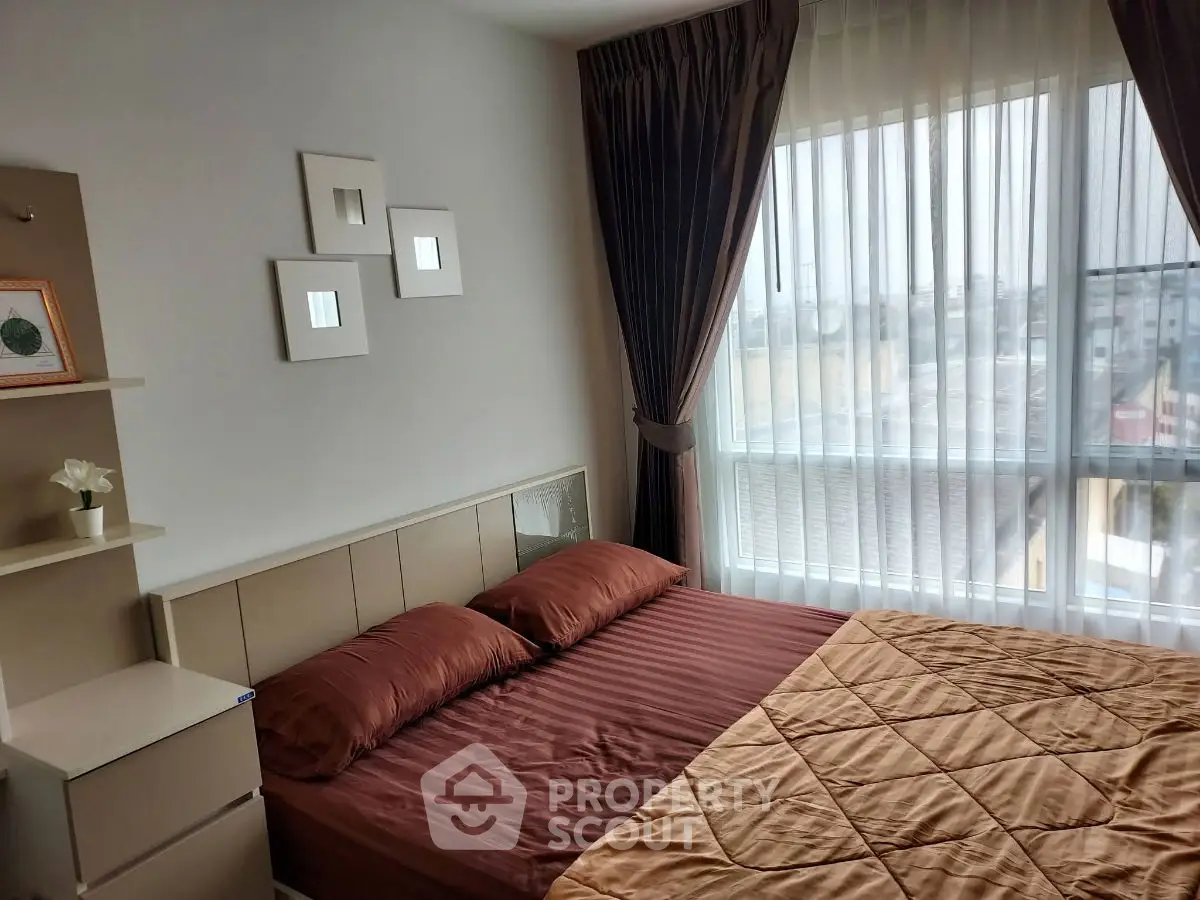 Cozy bedroom with large window and elegant curtains in modern apartment