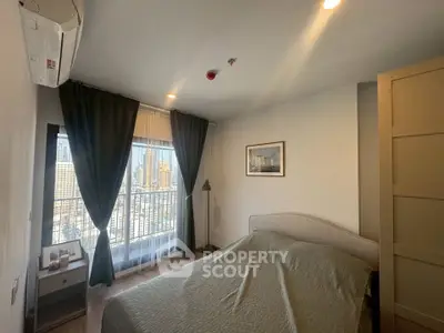 Cozy bedroom with city view, featuring a comfortable bed and elegant decor.