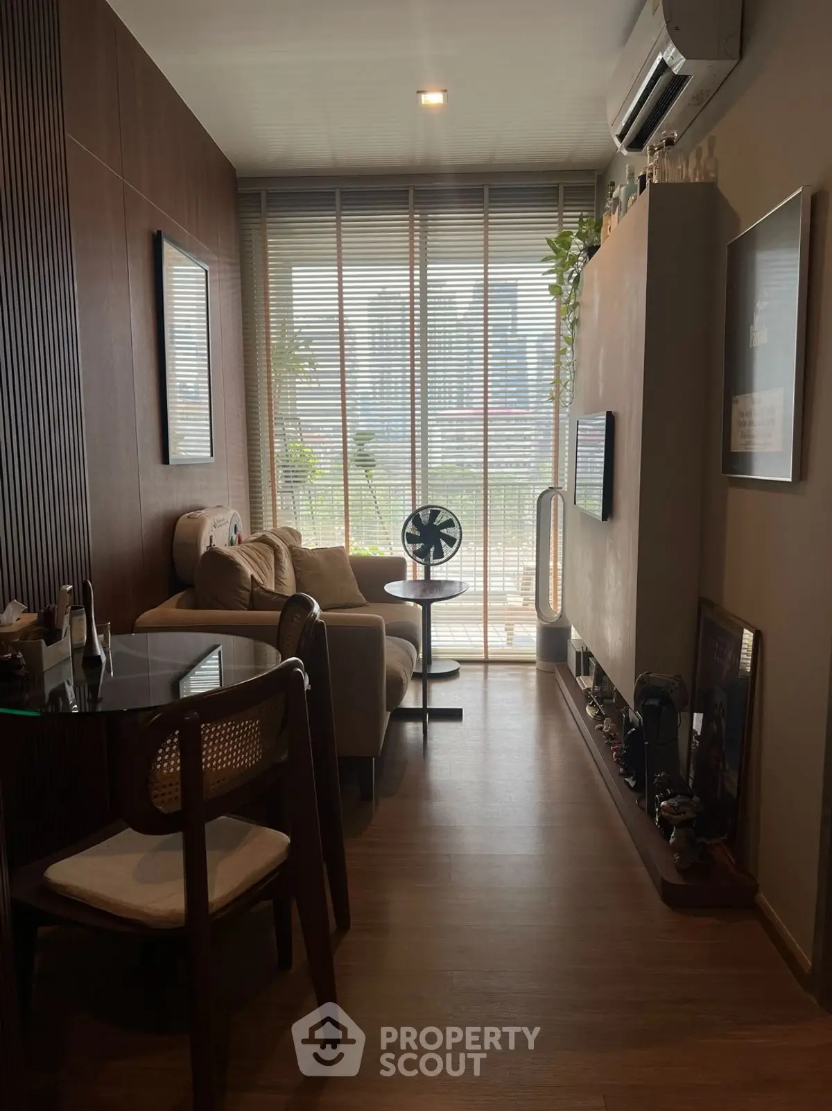Stylish living room with modern decor and large window offering city view.