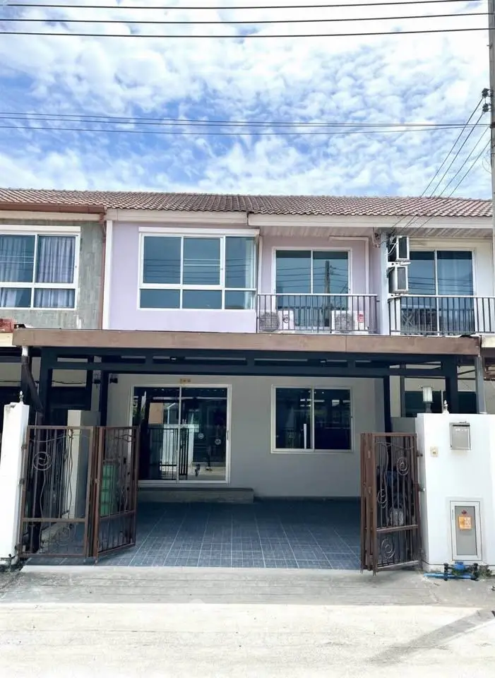 Charming townhouse with spacious driveway and modern facade in a serene neighborhood.