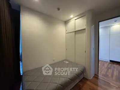 Cozy bedroom with built-in closet and wooden flooring, perfect for modern living.
