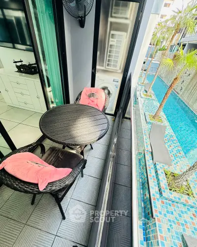 Charming balcony with pool view, perfect for relaxation and leisure in a modern apartment setting.