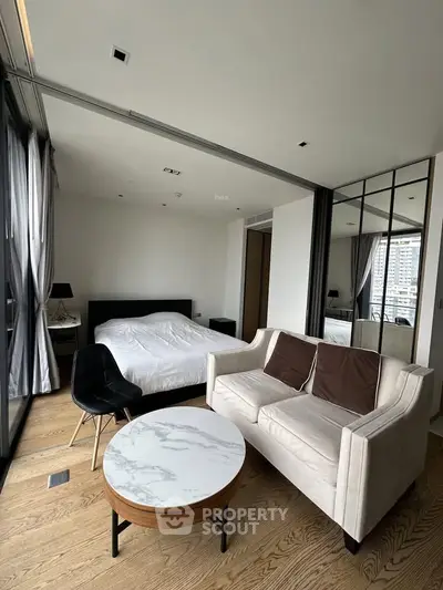 Modern studio apartment with stylish furnishings and large windows offering city views.