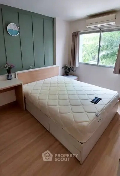 Cozy bedroom with large window and modern decor in a stylish apartment.