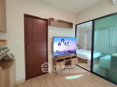 Modern living room with wooden flooring and sliding glass door to bedroom