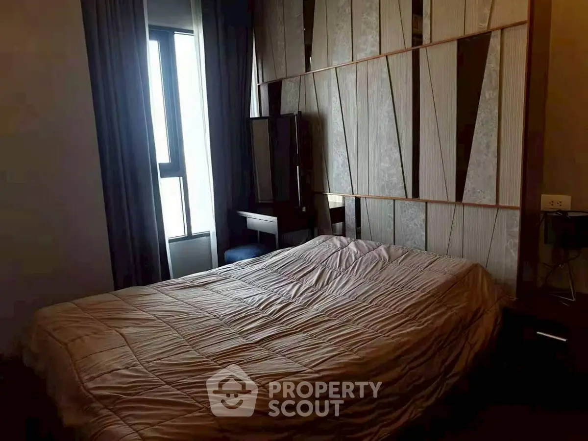 Cozy bedroom with modern decor and large window for natural light.