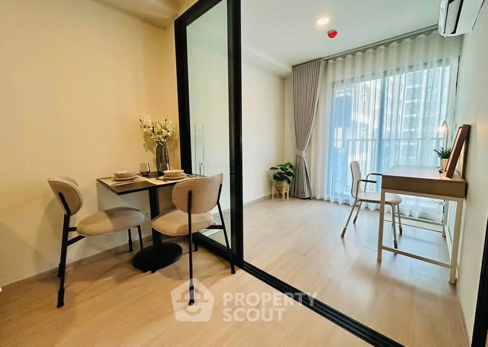 Modern apartment with glass partition, dining area, and bright workspace with balcony view.