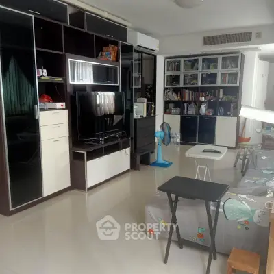 Spacious living room with modern entertainment center and ample storage space.