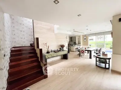 Spacious open-plan living area with modern decor and large windows.