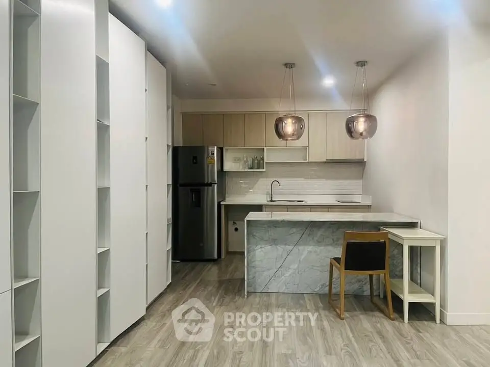 Modern kitchen with sleek cabinetry and stylish lighting in a contemporary apartment.