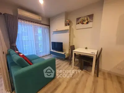 Cozy living room with teal sofa, wall-mounted TV, and dining area in modern apartment.