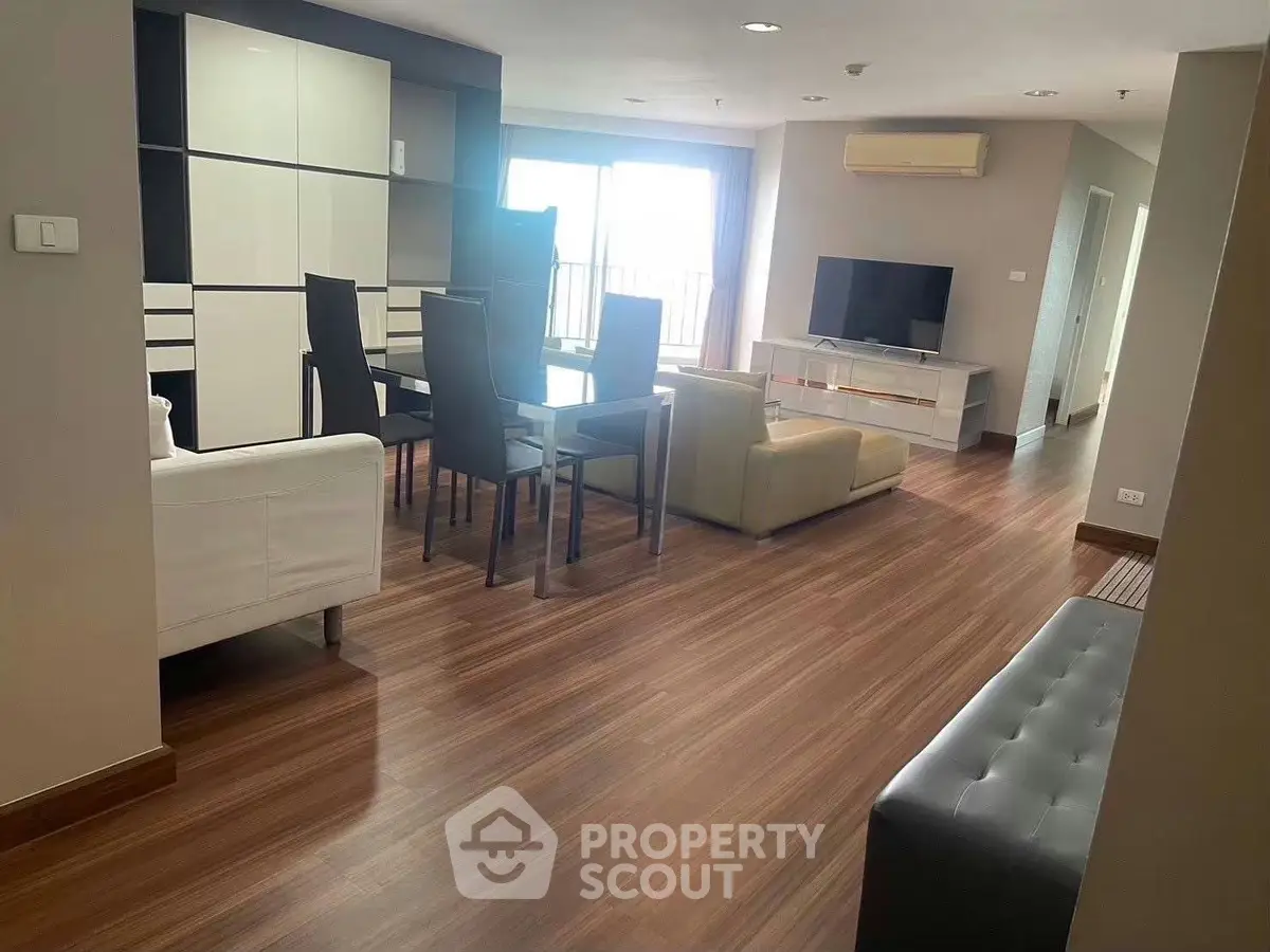 Spacious modern living room with sleek furniture and wooden flooring, perfect for comfortable living.