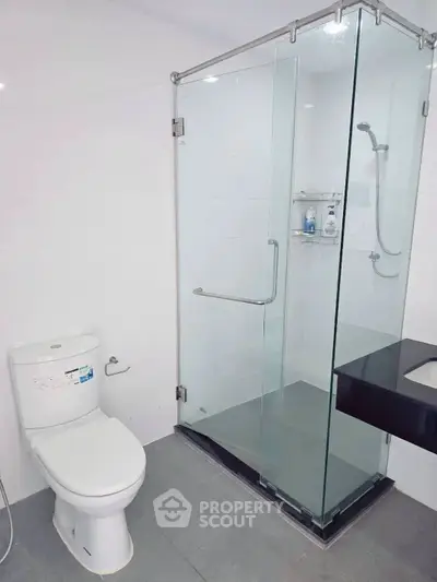 Modern bathroom with glass shower enclosure and sleek fixtures