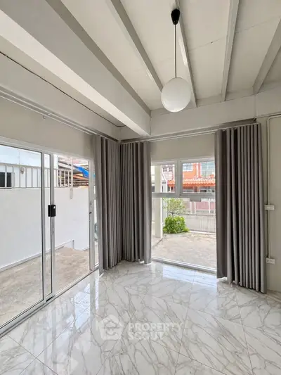Spacious modern living room with marble flooring and large windows