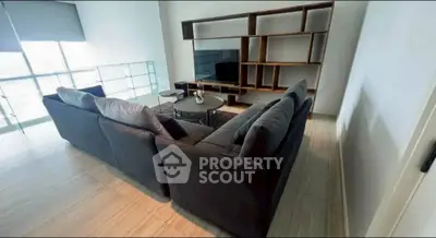 Spacious living room with modern sectional sofa and stylish shelving unit.