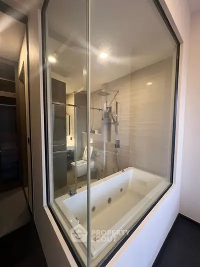 Luxurious bathroom with modern bathtub and glass partition in a contemporary home.