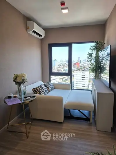 Modern living room with city view, featuring a cozy white sofa, air conditioning, and stylish decor.