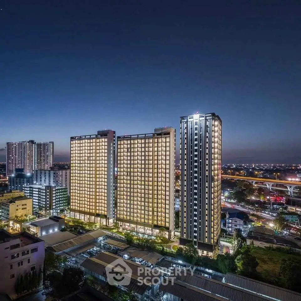 Stunning night view of modern high-rise buildings with cityscape backdrop, showcasing urban living at its finest.