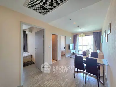 Spacious modern living room with dining area and natural light in a stylish apartment.