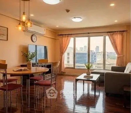 Spacious living room with large windows and city view, featuring modern furniture and elegant lighting.