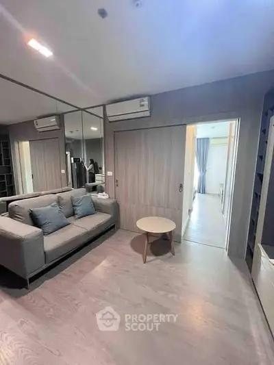 Modern living room with sleek design, featuring a cozy sofa and stylish wooden flooring.