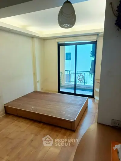 Spacious bedroom with platform bed and balcony access in modern apartment