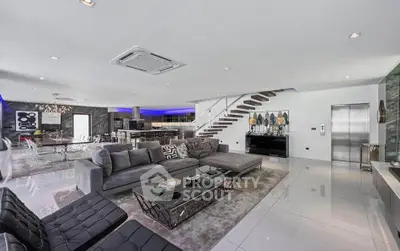 Luxurious open-plan living room with modern decor and sleek staircase