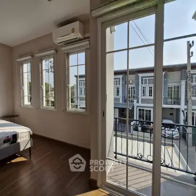 Spacious bedroom with balcony and street view in modern townhouse