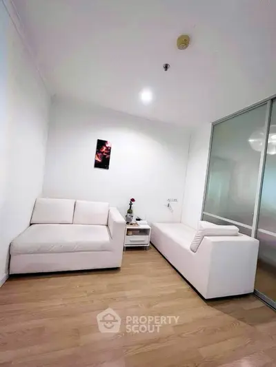 Modern living room with white sofas and wooden flooring