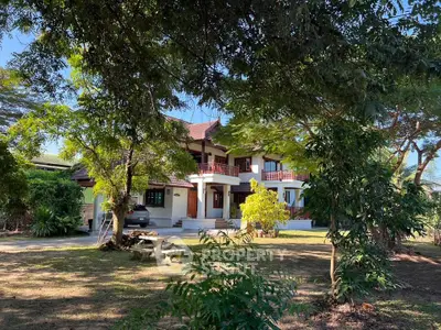 Charming two-story house with lush garden and spacious driveway, perfect for serene living.