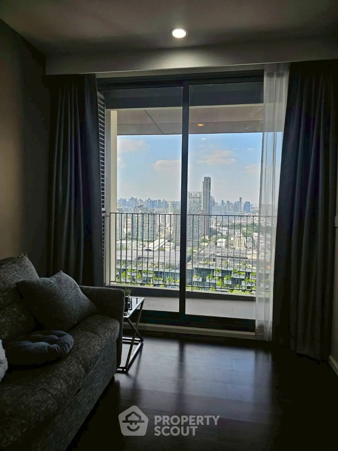 Modern living room with stunning city view from large balcony window.