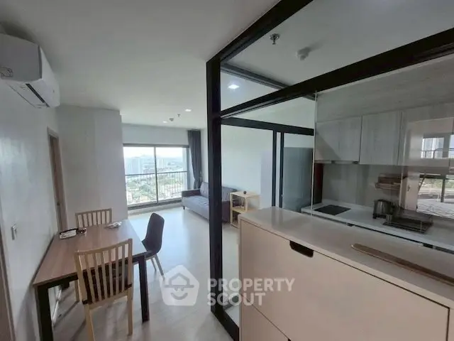 Modern open-plan living room with kitchen and balcony view
