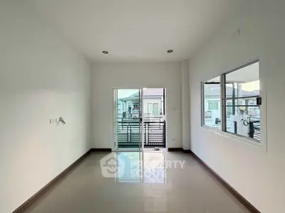 Spacious unfurnished room with large window and balcony view in modern apartment.