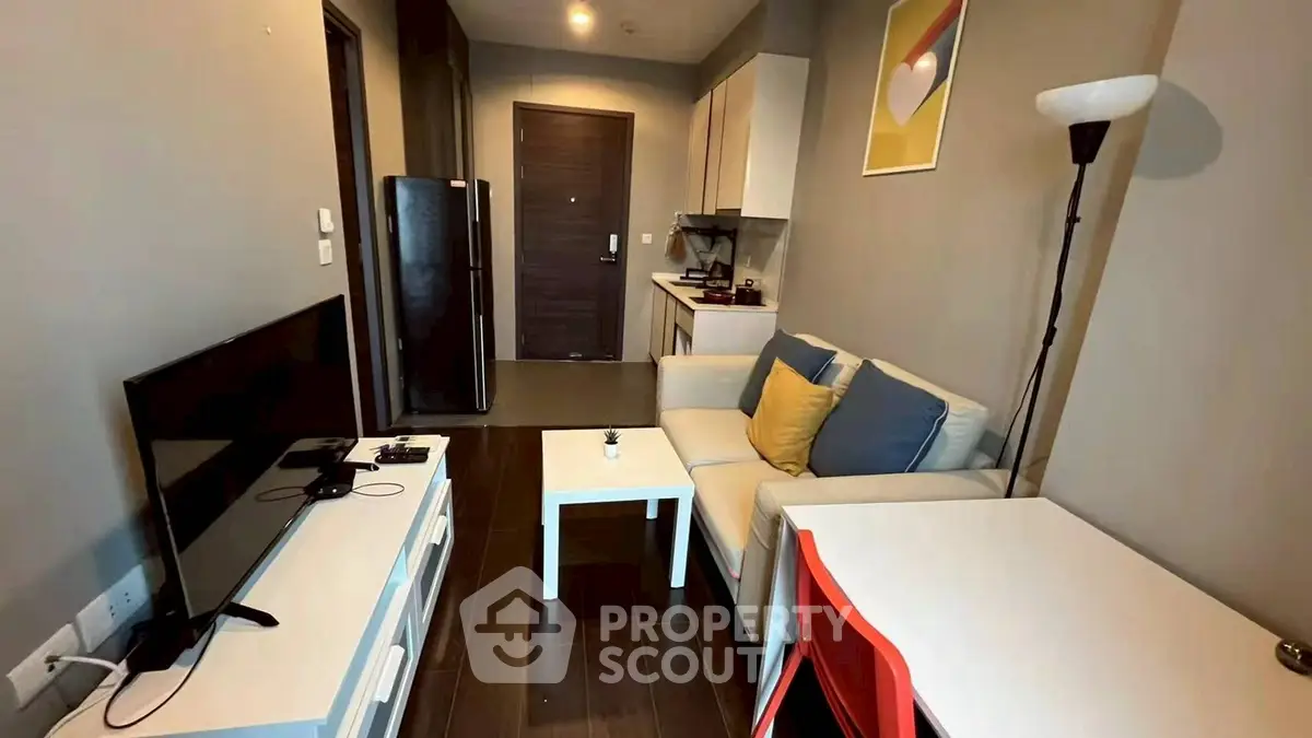 Modern living room with sleek furniture and open kitchen layout in cozy apartment.