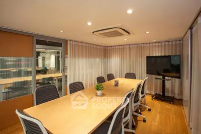 Modern conference room with wooden table and chairs, ideal for meetings and presentations.