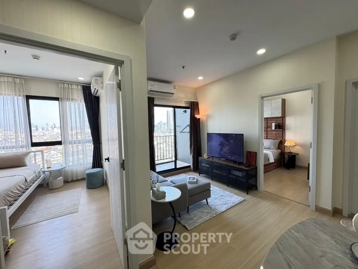 Modern apartment interior with open living room and city view, featuring stylish decor and natural light.