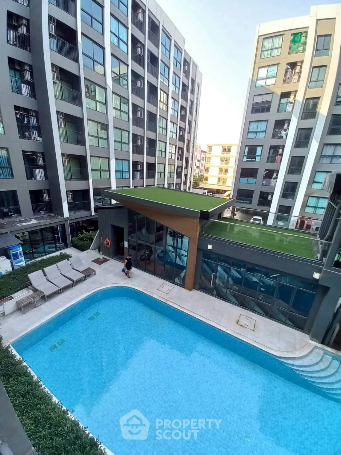 Modern apartment complex with a pristine swimming pool and stylish architecture.